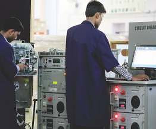 Engineer operating an electrical test bench at C-SEC